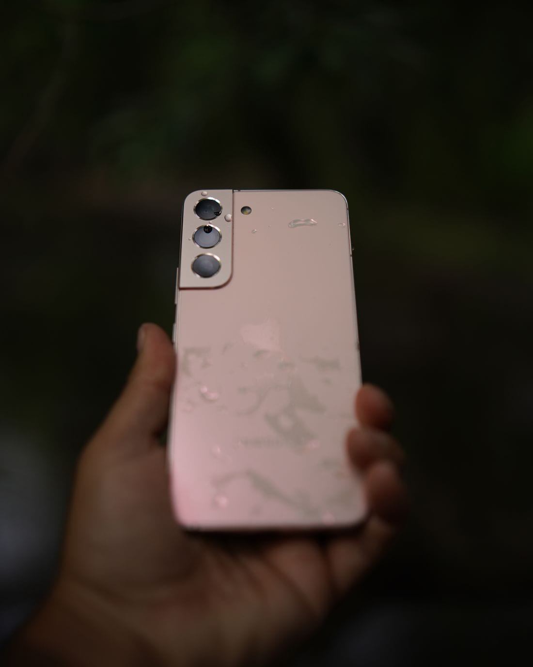 Celular com gotas sobre a superfície em ambiente externo